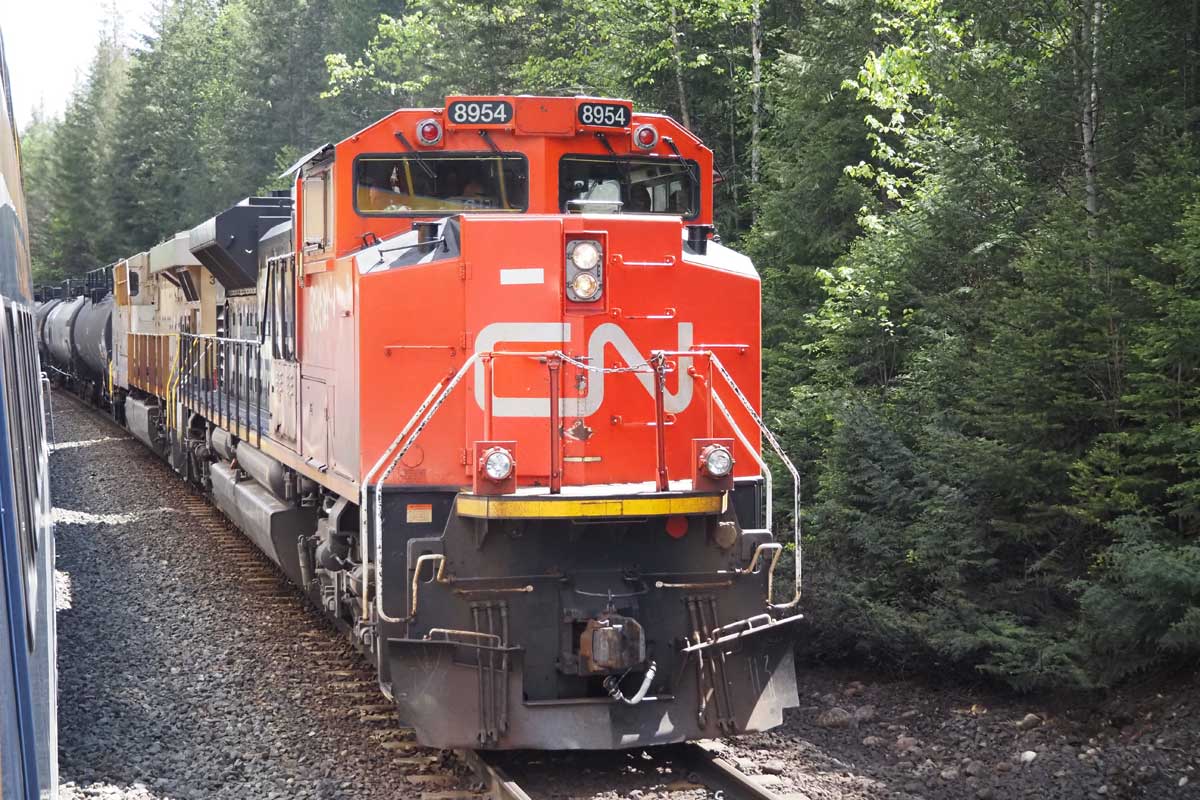 ロッキーマウンテニアの脇を通過するカナディアン・ナショナル鉄道(CN)の貨物列車(大塚圭一郎撮影)
