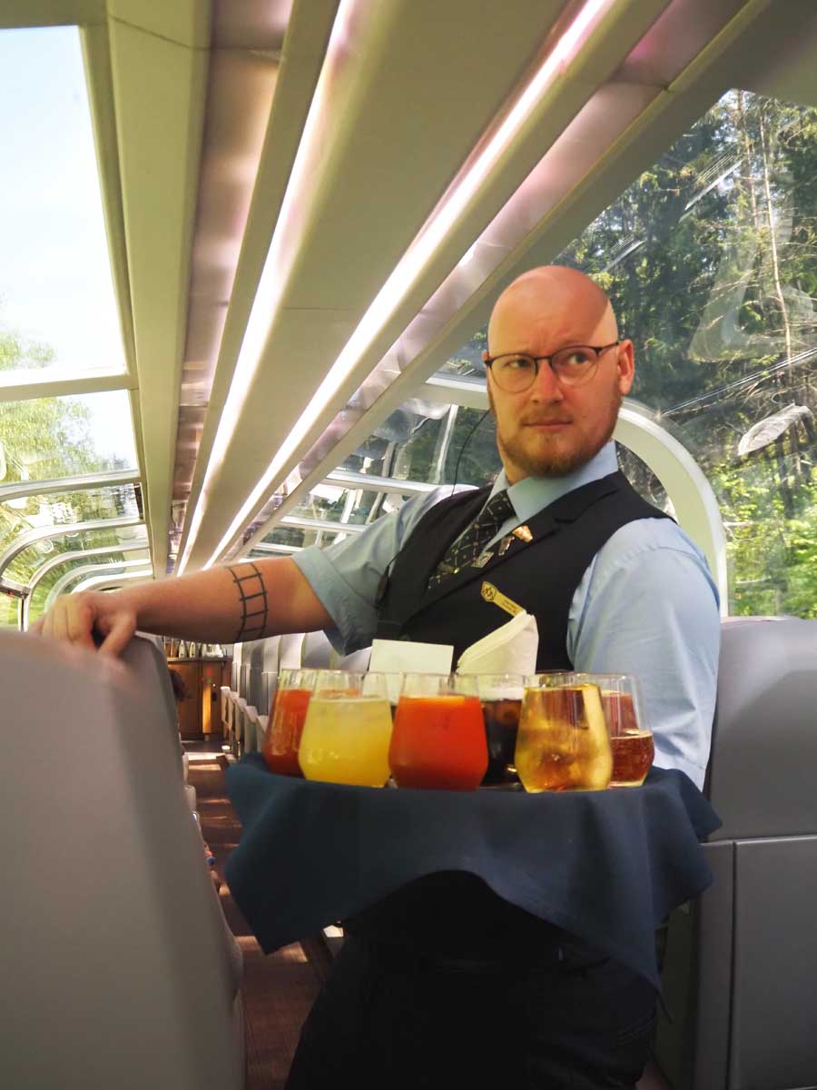 飲み物を配る客室乗務員のジェームズさん（大塚圭一郎撮影）